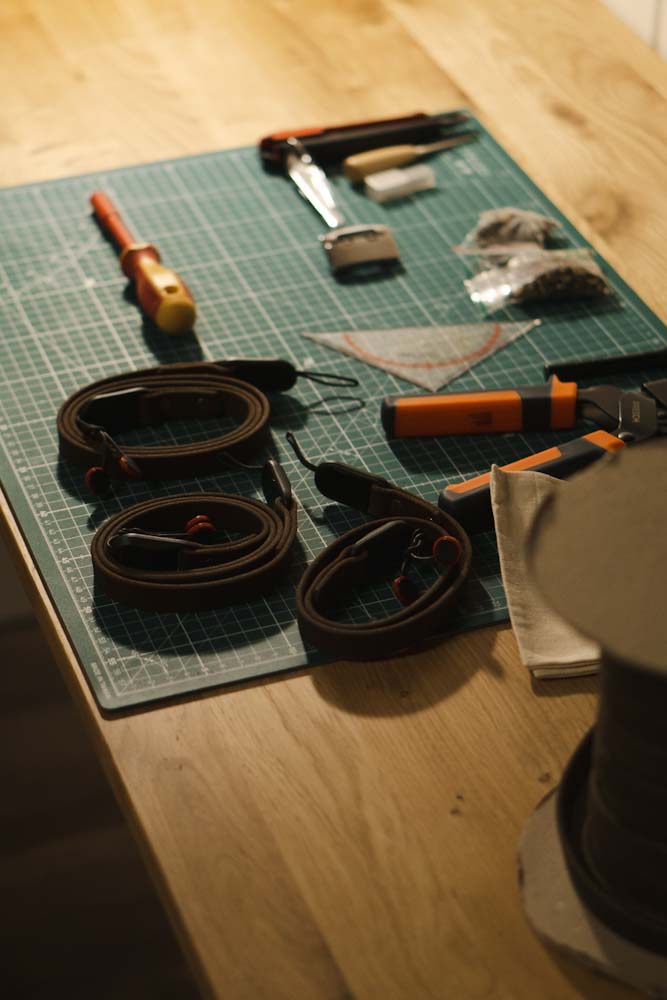 Arbeitsplatz einer Manufaktur für Kameragurte auf einem Holztisch